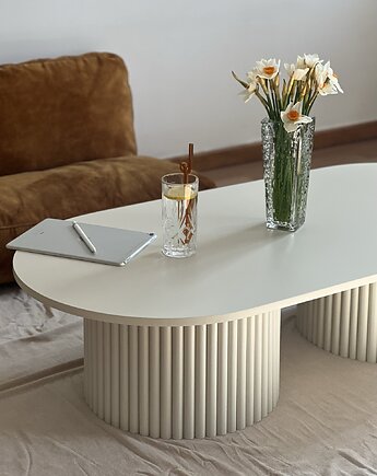 Owalny stolik kawowy w kolorze jasnego beżu na 2 podstawach wysokość 40 cm, tr.tables