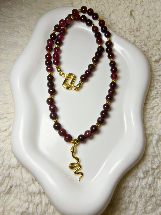 korale Bądź silna! Z tym naszyjnikiem z granatami i hematytem.