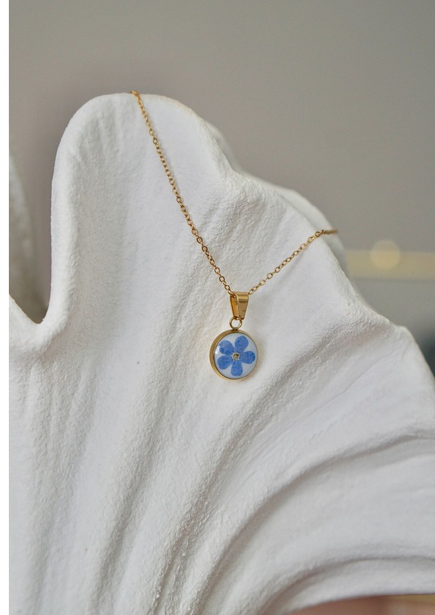 złote naszyjniki Naszyjnik z niezapominajką na białym tle