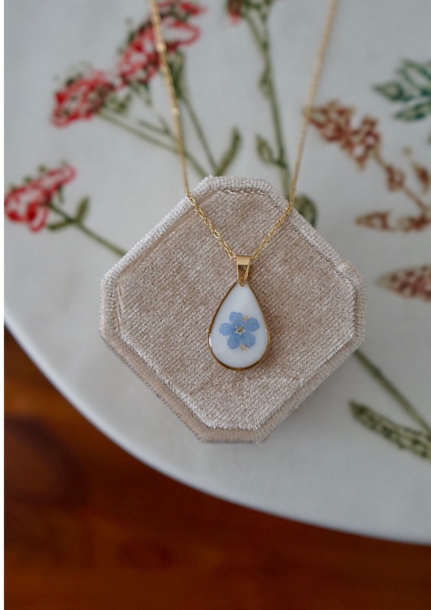 złote naszyjniki Naszyjnik z niezapominajką na białym tle