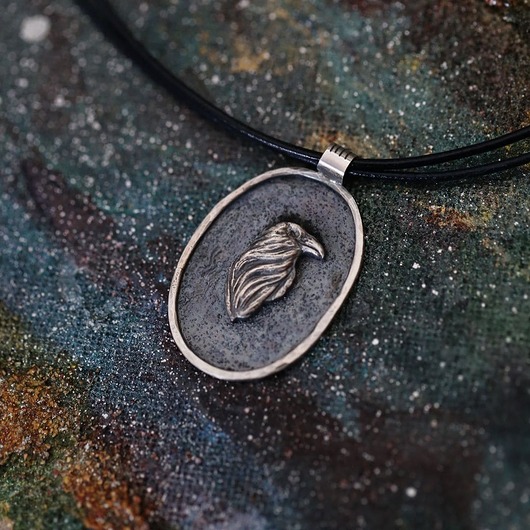 wisiory Owalny wisior ze srebrnym krukiem