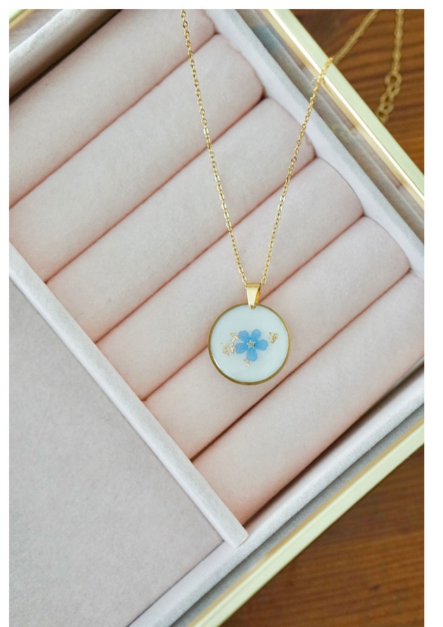 złote naszyjniki Naszyjnik z niezapominajką na białym tle