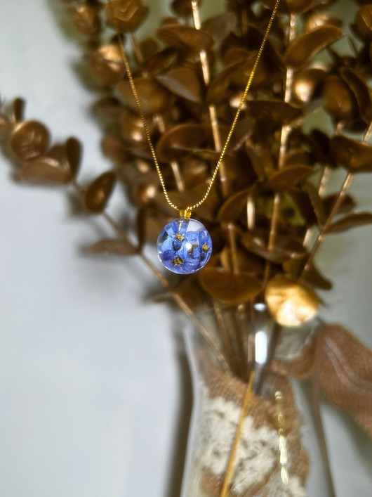 złote naszyjniki Naszyjnik z niezapominajkami zamkniętymi w kulce z żywicy