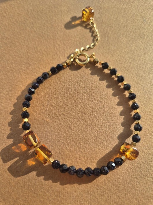 bransoletki z kamieni naturalnych Złota bransoletka z granatowych "nocy Kairu" i bursztynów z zawieszką